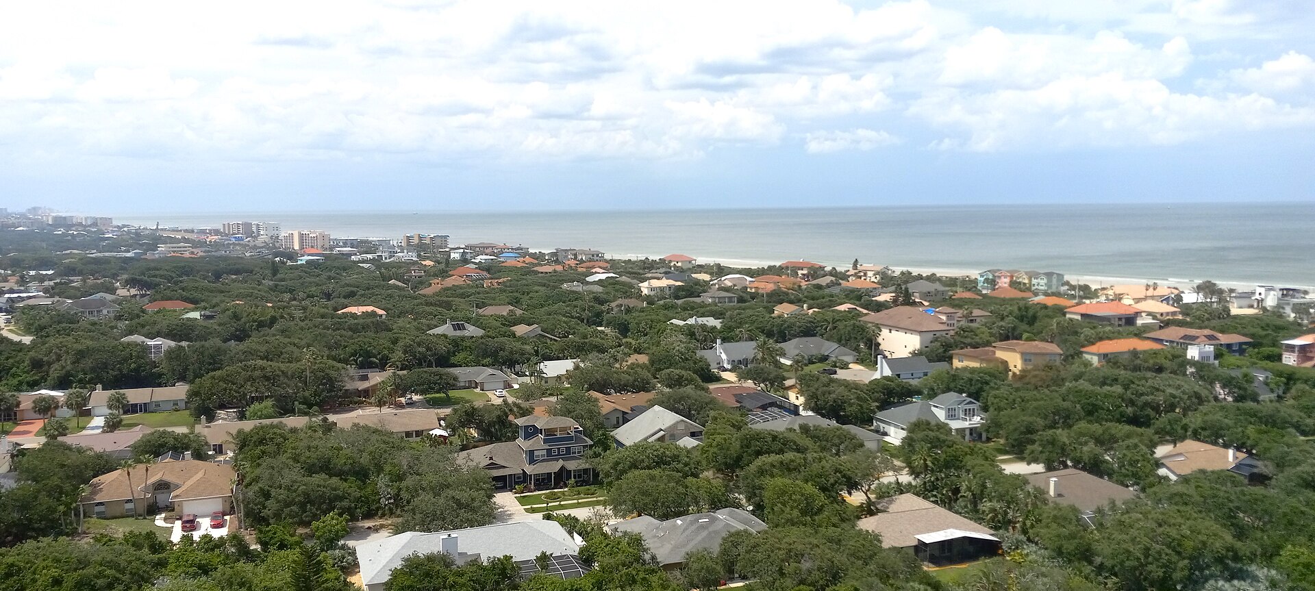 Aerial view of Ponce Inlet, Florida — the red Ponce de Leon Lighthouse, turquoise inlet waters and white sand beach